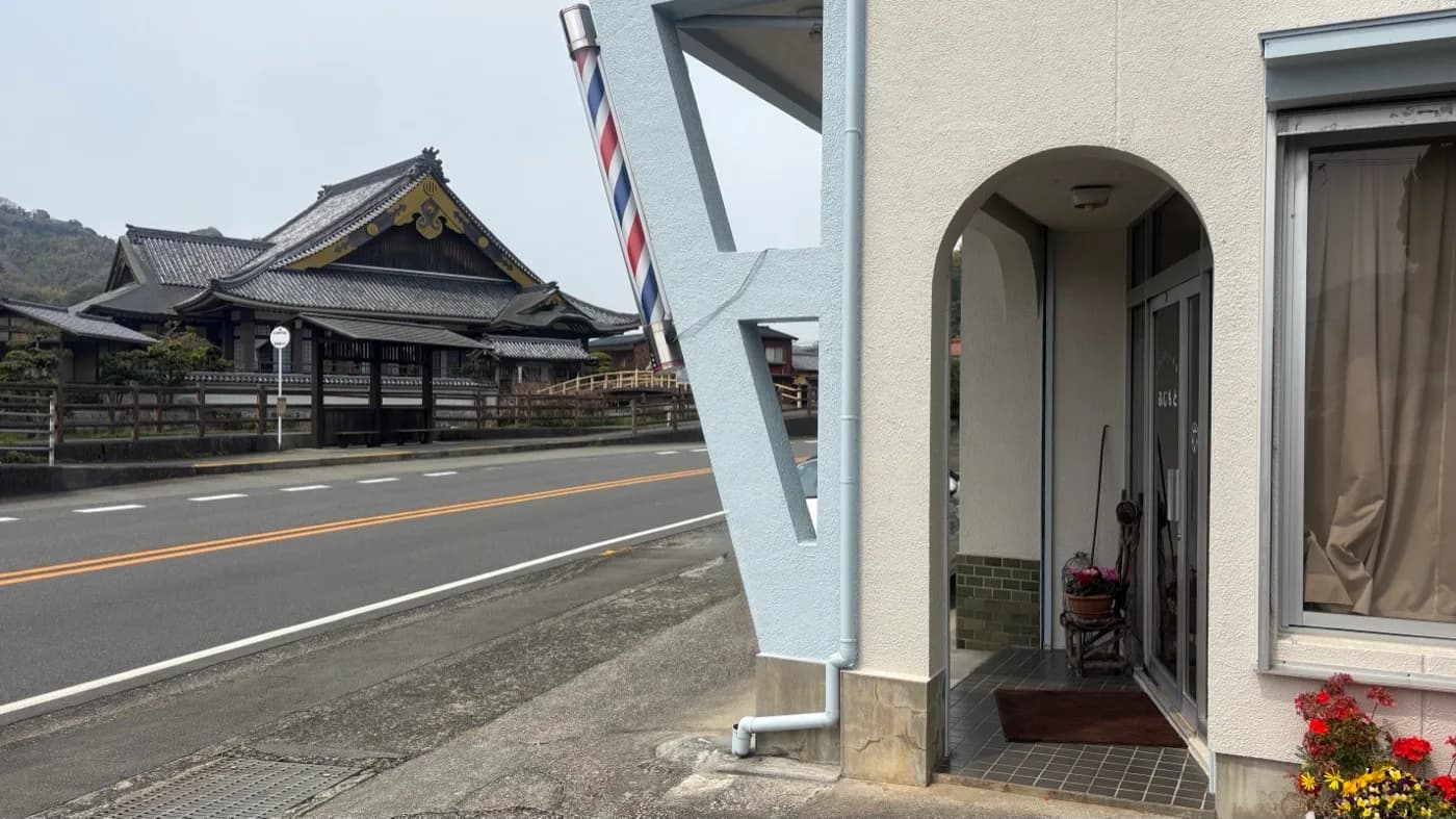 店舗外観。左側に吉田町図書館の瓦屋根、手前にバーバーポールが目印です